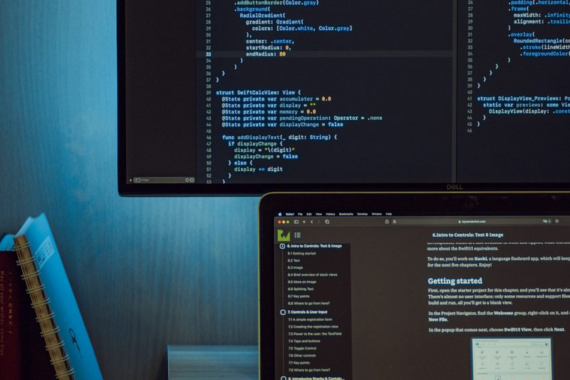 Entwickler arbeitet an Quellcode auf mehreren Bildschirmen